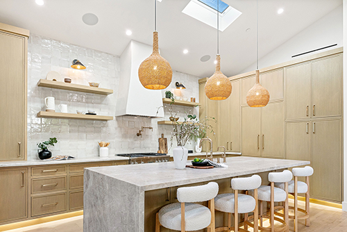 Light-filled kitchen with woven statement lighting, natural textures, and a stone island - blending warmth and organic luxury.